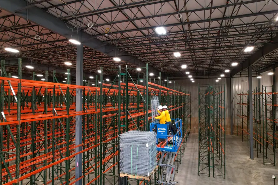 Forklift lifting wire decking in completed racking aisle